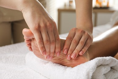 Photo of Woman receiving foot massage in spa salon, closeup