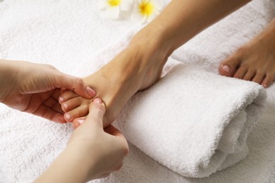 Photo of Woman receiving foot massage in spa salon, closeup