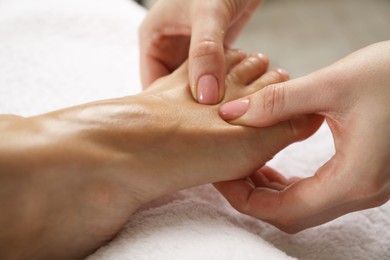 Photo of Woman receiving foot massage in spa salon, closeup