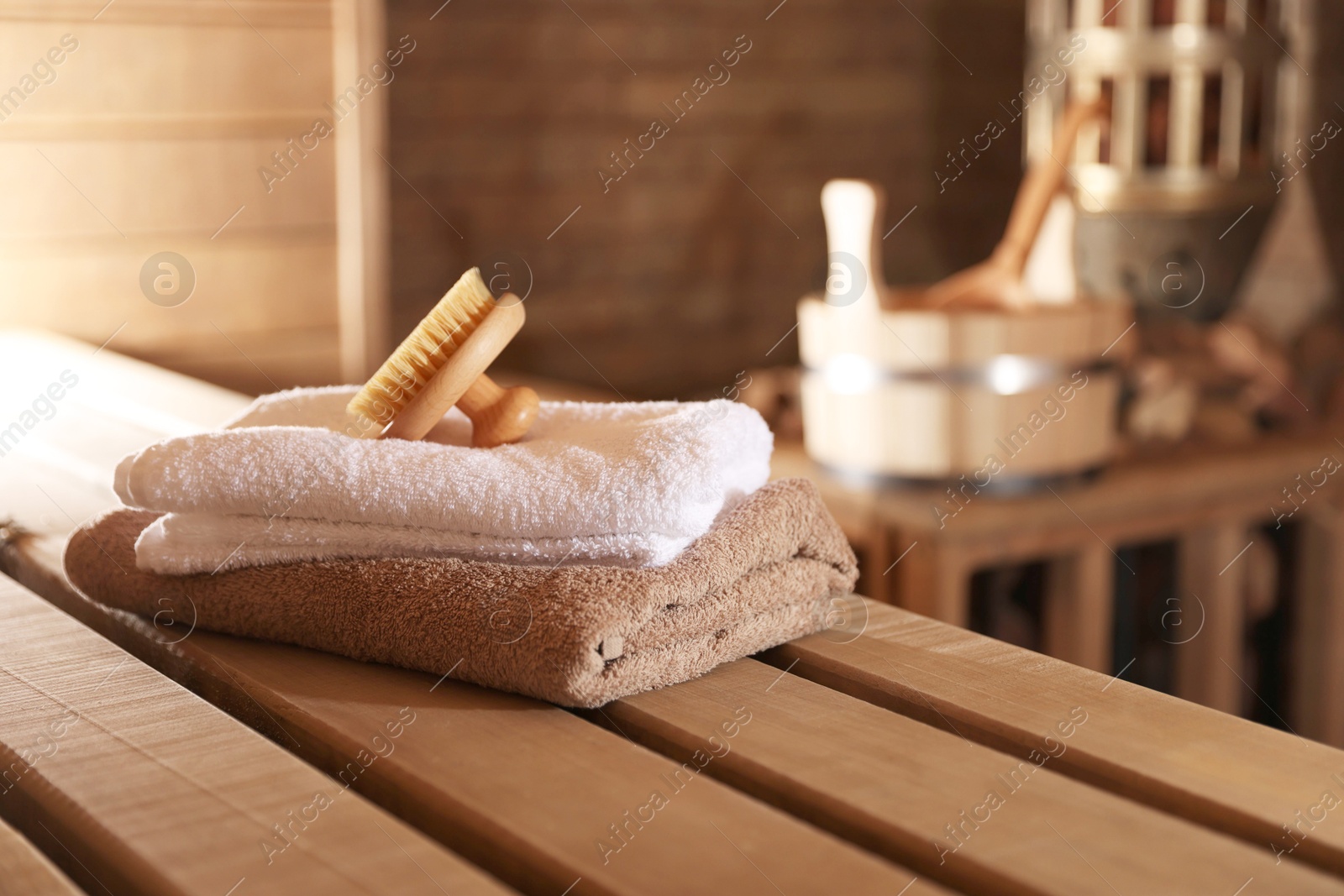 Massaging brush, stack of towels and other supplies in sauna Photo of Massaging brush, stack of towels and other supplies in sauna