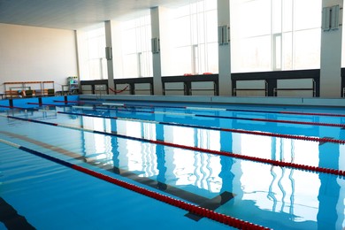 Photo of Swimming pool with clean water and lane dividers indoors