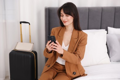 Photo of Businesswoman with smartphone in her hotel room