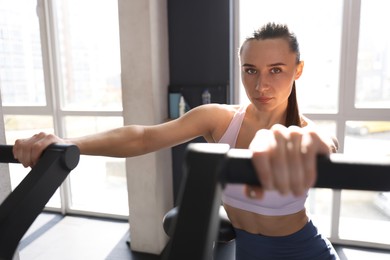 Photo of Athletic woman training on exercise bike in gym