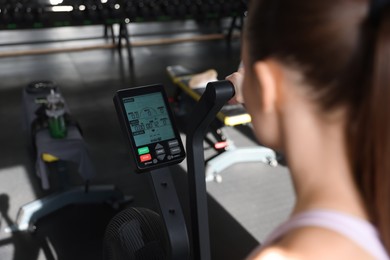 Photo of Woman training in gym, focus on exercise bike