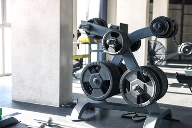 Photo of Different weight plates on rack in modern gym