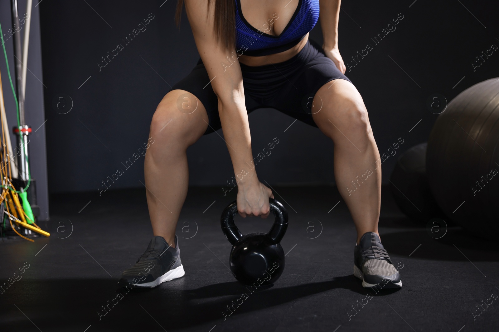 Photo of Woman training with kettlebell in gym, closeup