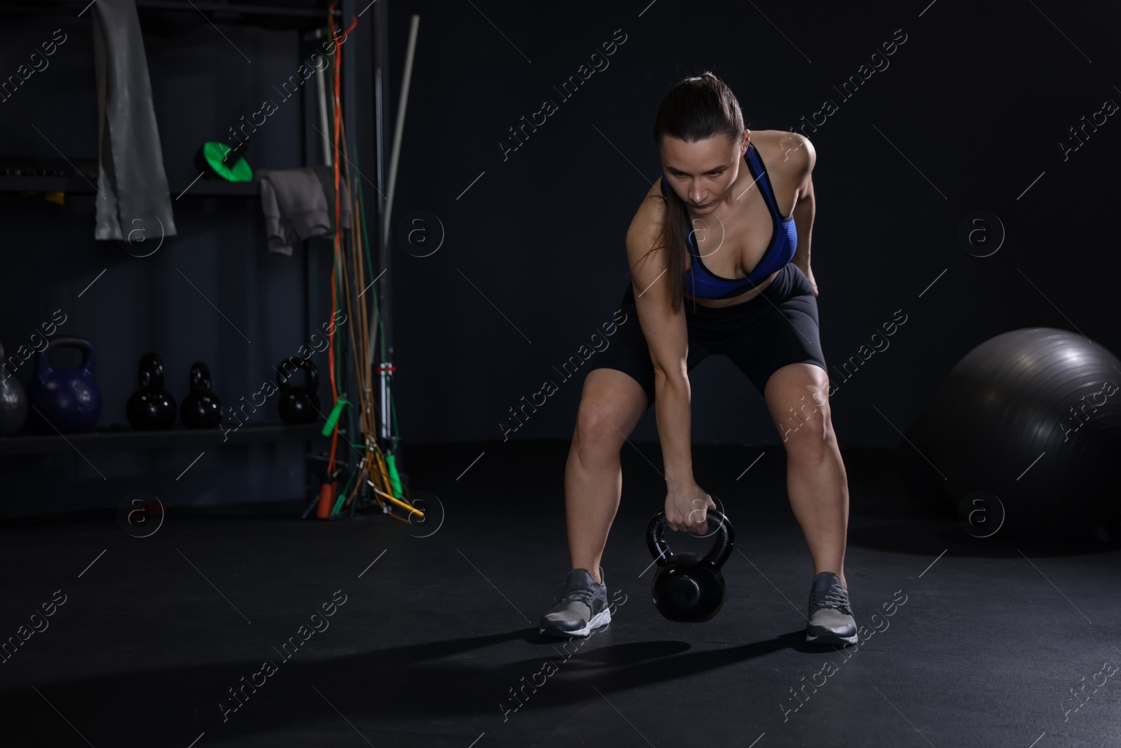 Photo of Athletic woman training with kettlebell in gym. Space for text