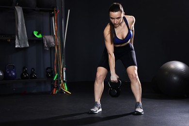 Photo of Athletic woman training with kettlebell in gym. Space for text