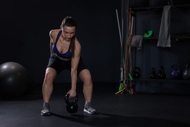 Photo of Athletic woman training with kettlebell in gym. Space for text