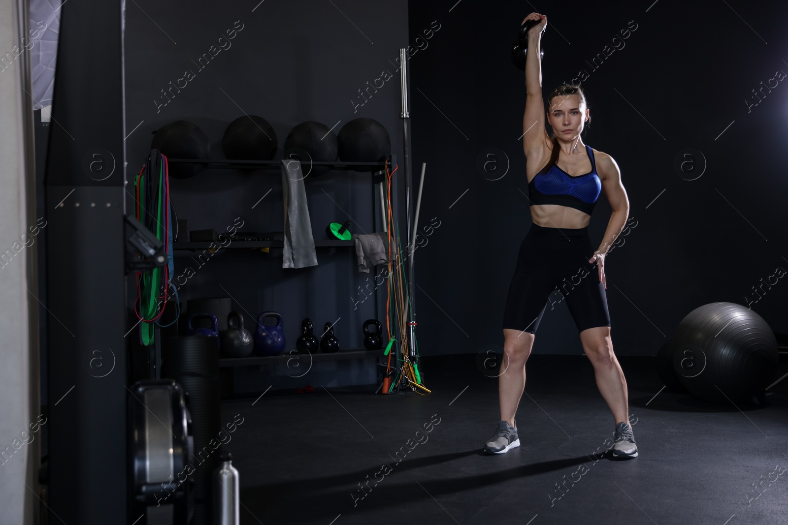 Photo of Athletic woman training with kettlebell in gym. Space for text