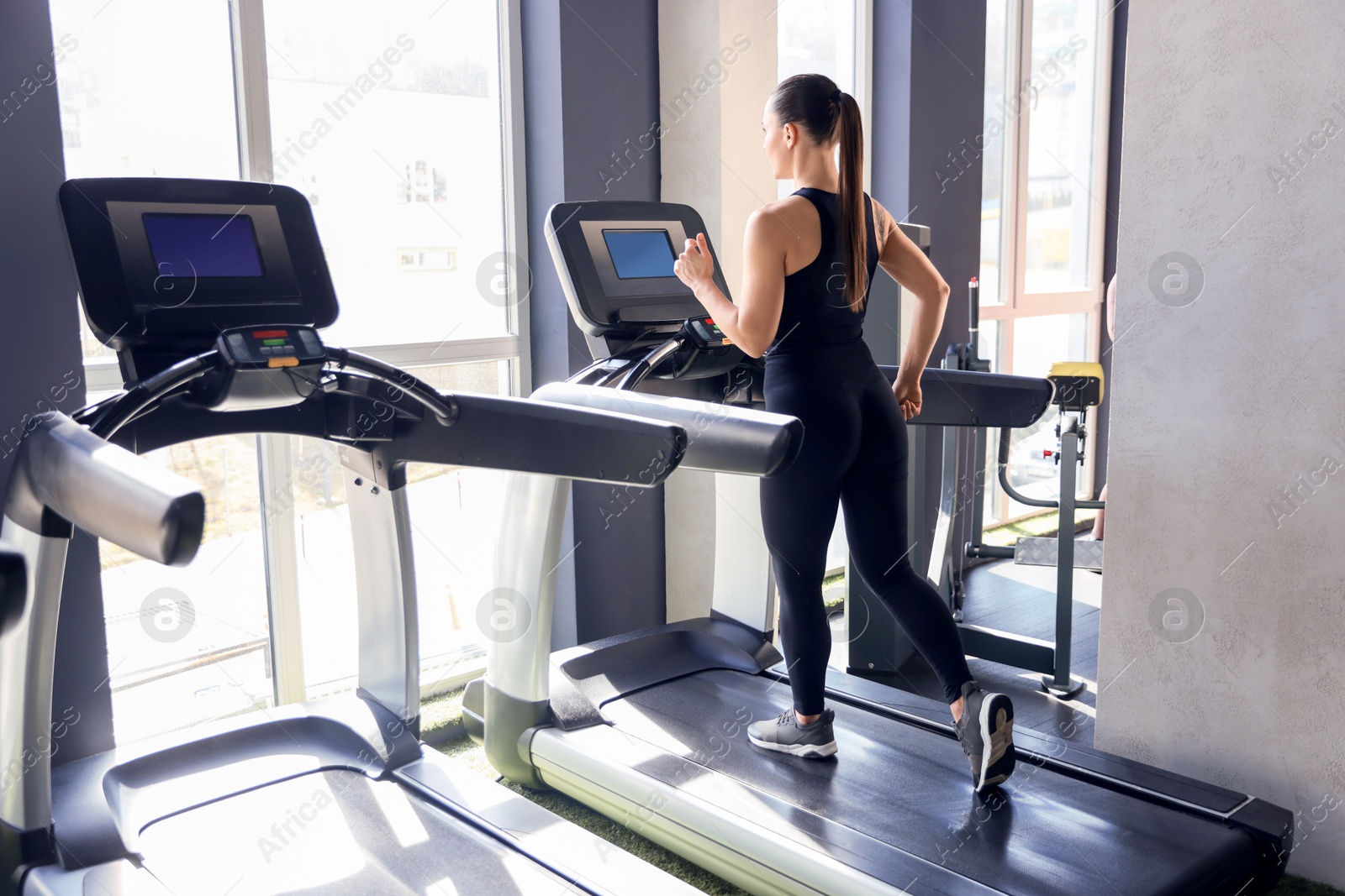 Photo of Athletic woman training on treadmill in gym