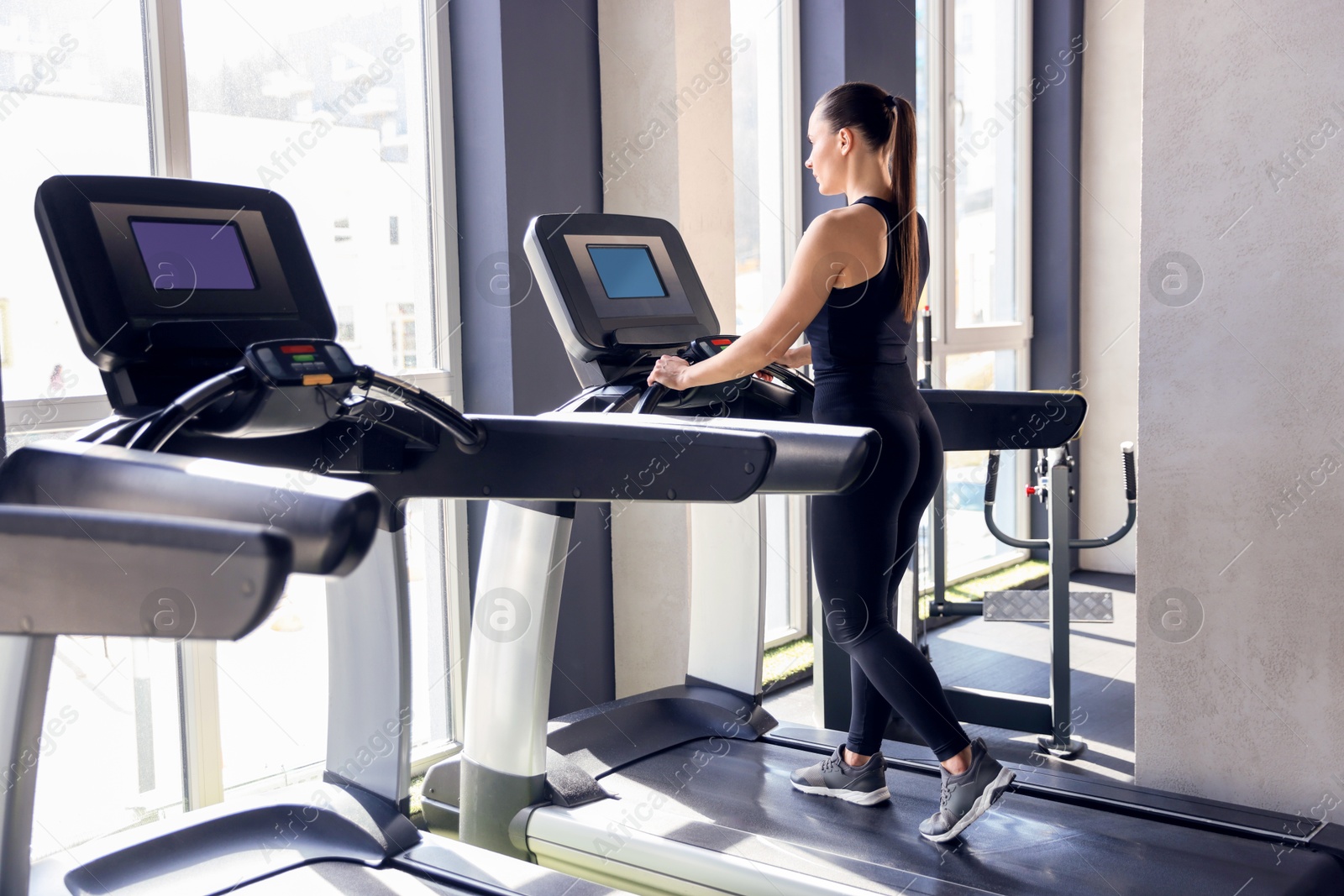 Photo of Athletic woman training on treadmill in gym