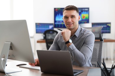 Photo of Financial trading specialist working on computer in office