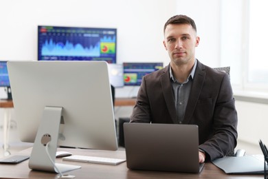 Photo of Financial trading specialist with laptop in office