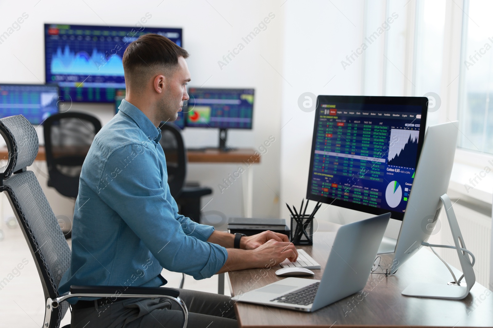 Photo of Financial trading specialist working on computer in office