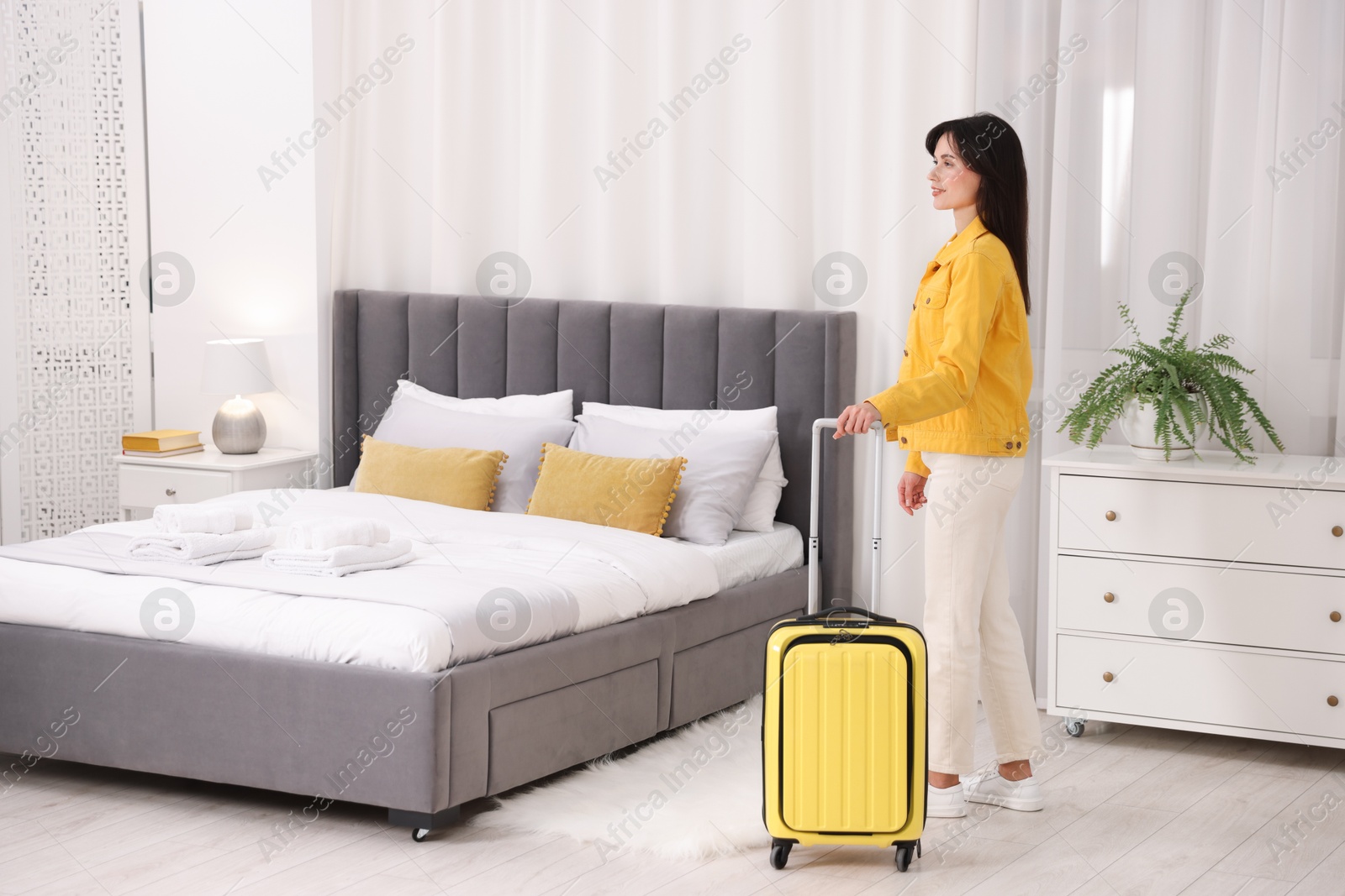 Photo of Woman with suitcase in her hotel room