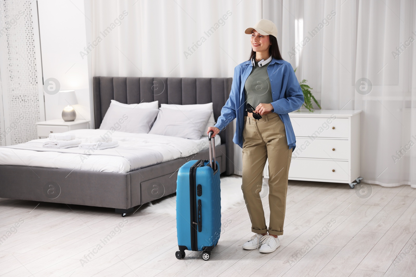 Photo of Woman with suitcase in her hotel room