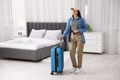 Photo of Woman with suitcase in her hotel room