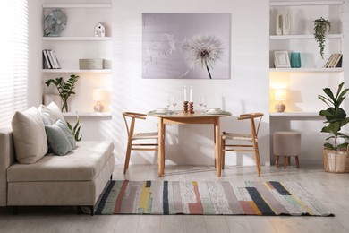 Photo of Stylish table setting, chairs and sofa in dining room. interior design