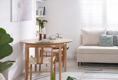 Photo of Stylish table setting, chairs and sofa in dining room. interior design