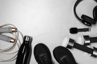 Photo of Different gym stuff, wrist watch and headphones on light grey textured background, flat lay. Space for text