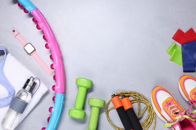 Photo of Different gym stuff and wrist watch on light grey textured background, flat lay. Space for text