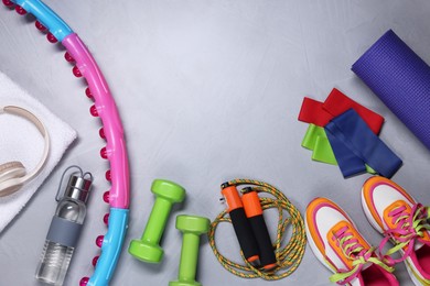 Photo of Different gym stuff and headphones on light grey textured background, flat lay. Space for text