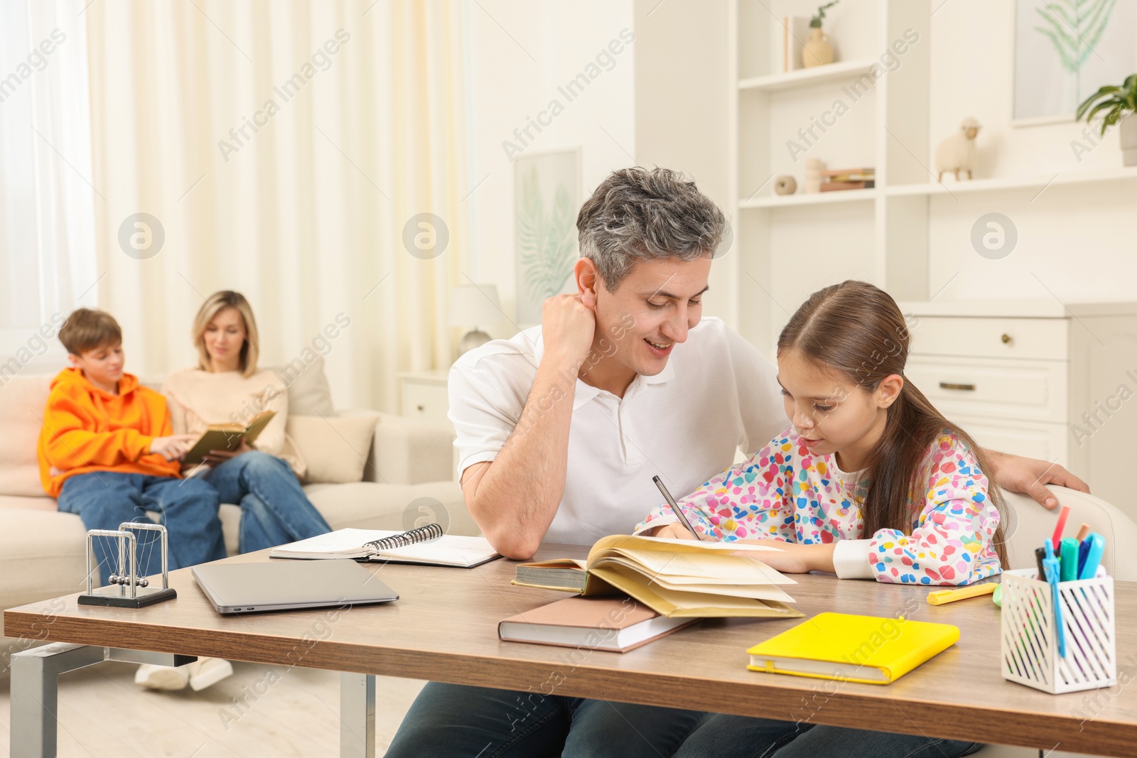 Photo of Parents and their children doing homework at home