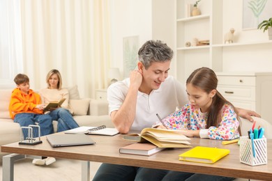 Photo of Parents and their children doing homework at home