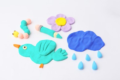 Photo of Different colorful child's crafts made of play dough on grey background, closeup