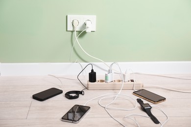 Photo of USB adapters with cables charging different devices indoors