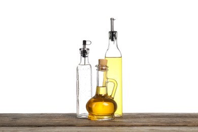 Photo of Salad dressings on wooden table against white background