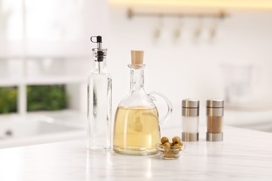 Photo of Salad dressings, spices and olives on table in kitchen