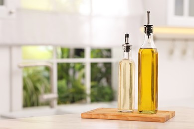 Photo of Oil and vinegar on table in kitchen. Space for text