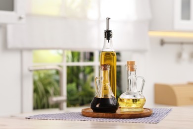 Photo of Salad dressings in bottles on table indoors. Space for text