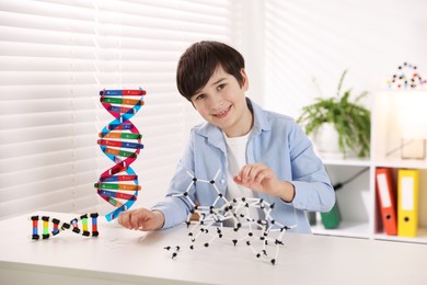 Photo of Boy making DNA structure model at desk indoors