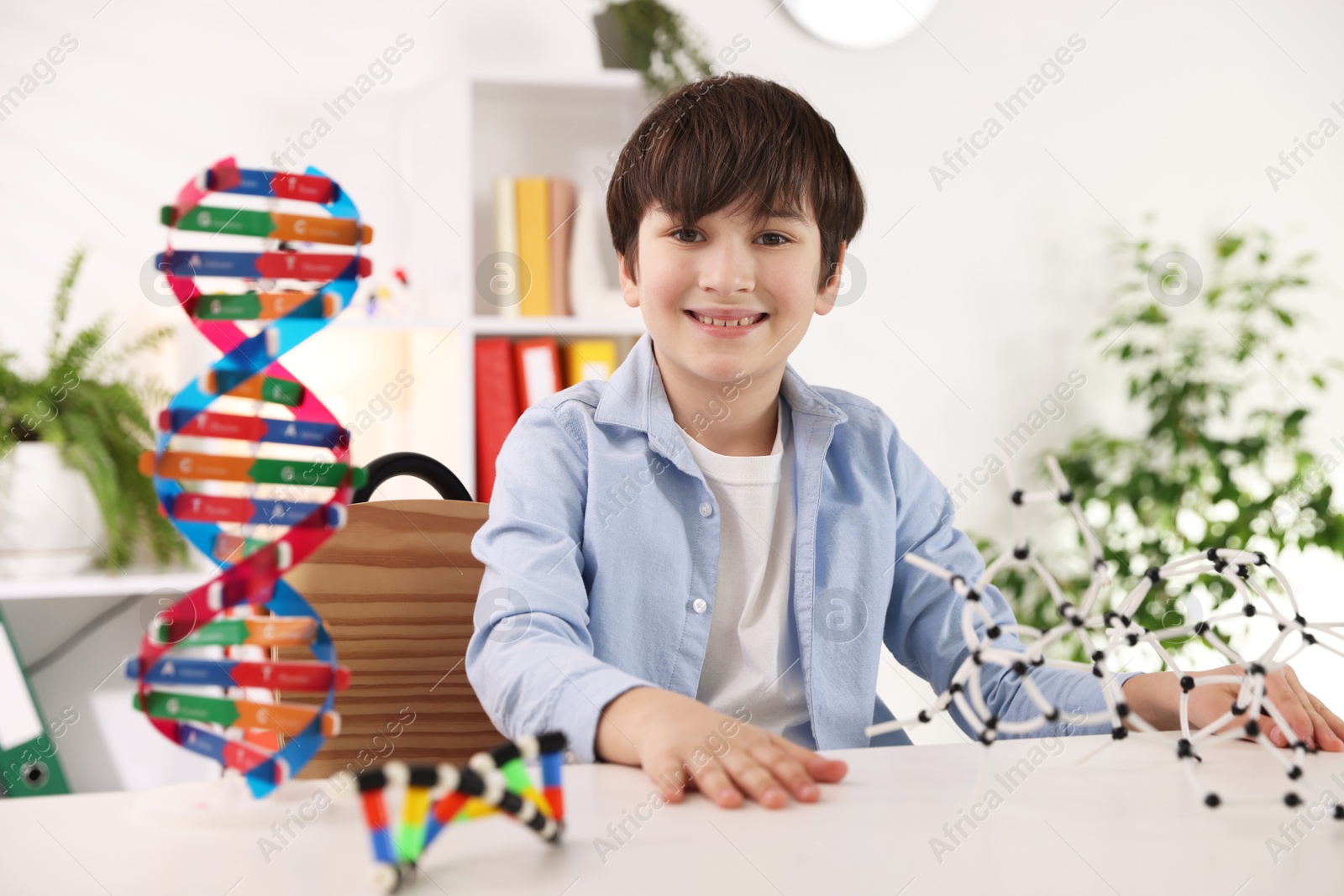 Photo of Boy with DNA structure model at desk indoors