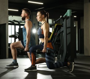 Photo of Athletic couple training with dumbbells in gym