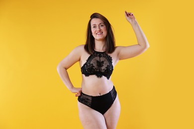 Photo of Woman in underwear on orange background. Cellulite problem