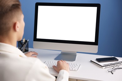 Photo of Man working on computer at white desk in office, closeup. Mockup for design