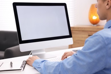 Photo of Man working on computer at white desk in office, closeup. Mockup for design