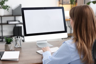 Photo of Woman working on computer at wooden desk in office. Mockup for design