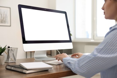 Photo of Woman working on computer at wooden desk in office, closeup. Mockup for design