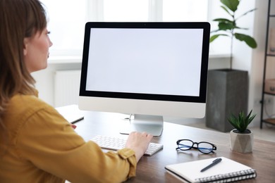 Photo of Woman working on computer at wooden desk in office. Mockup for design