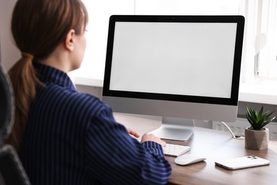 Photo of Woman working on computer at wooden desk in office. Mockup for design