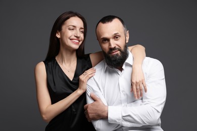 Photo of Happy daughter and father on dark grey background