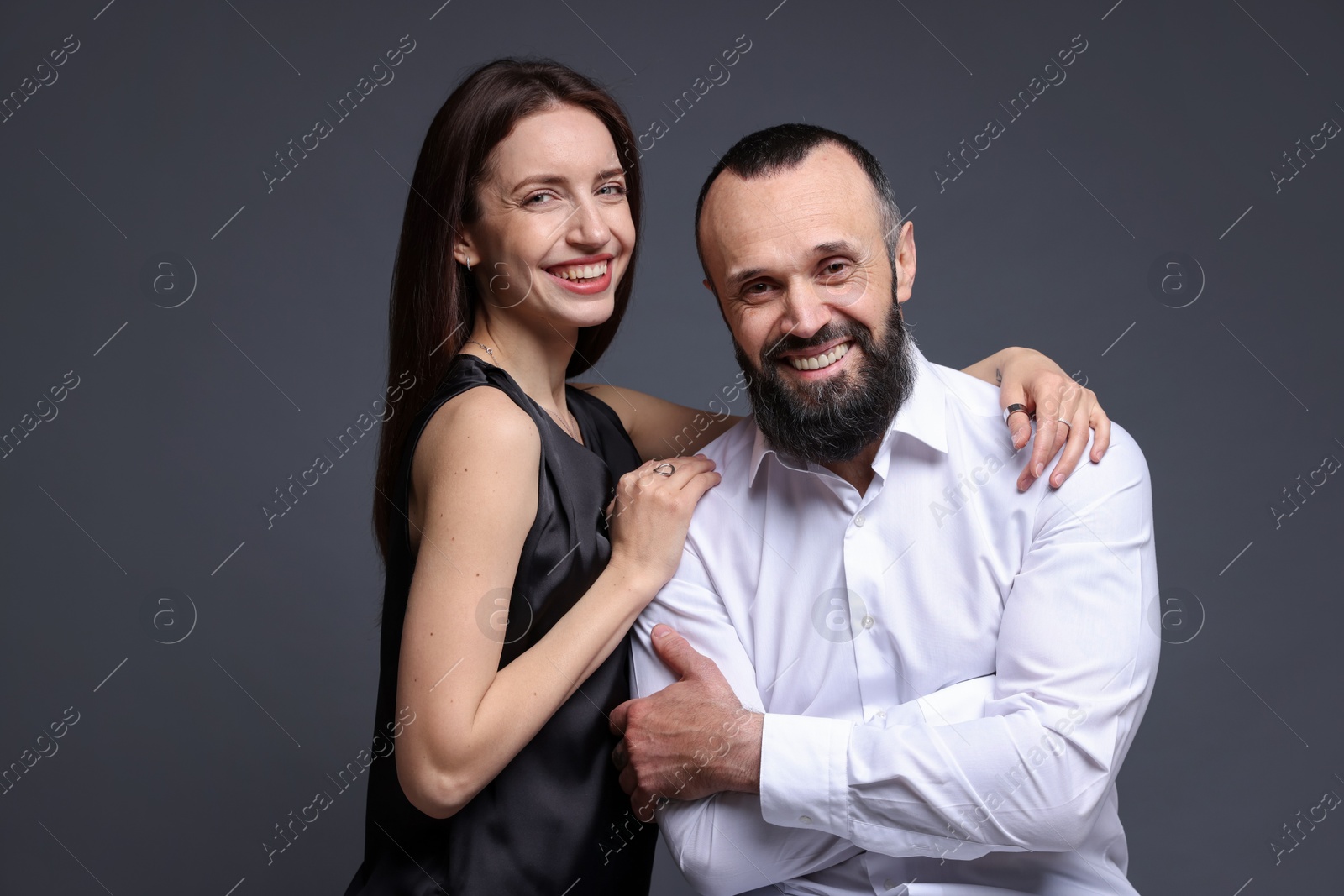 Photo of Portrait of happy daughter and father on dark grey background