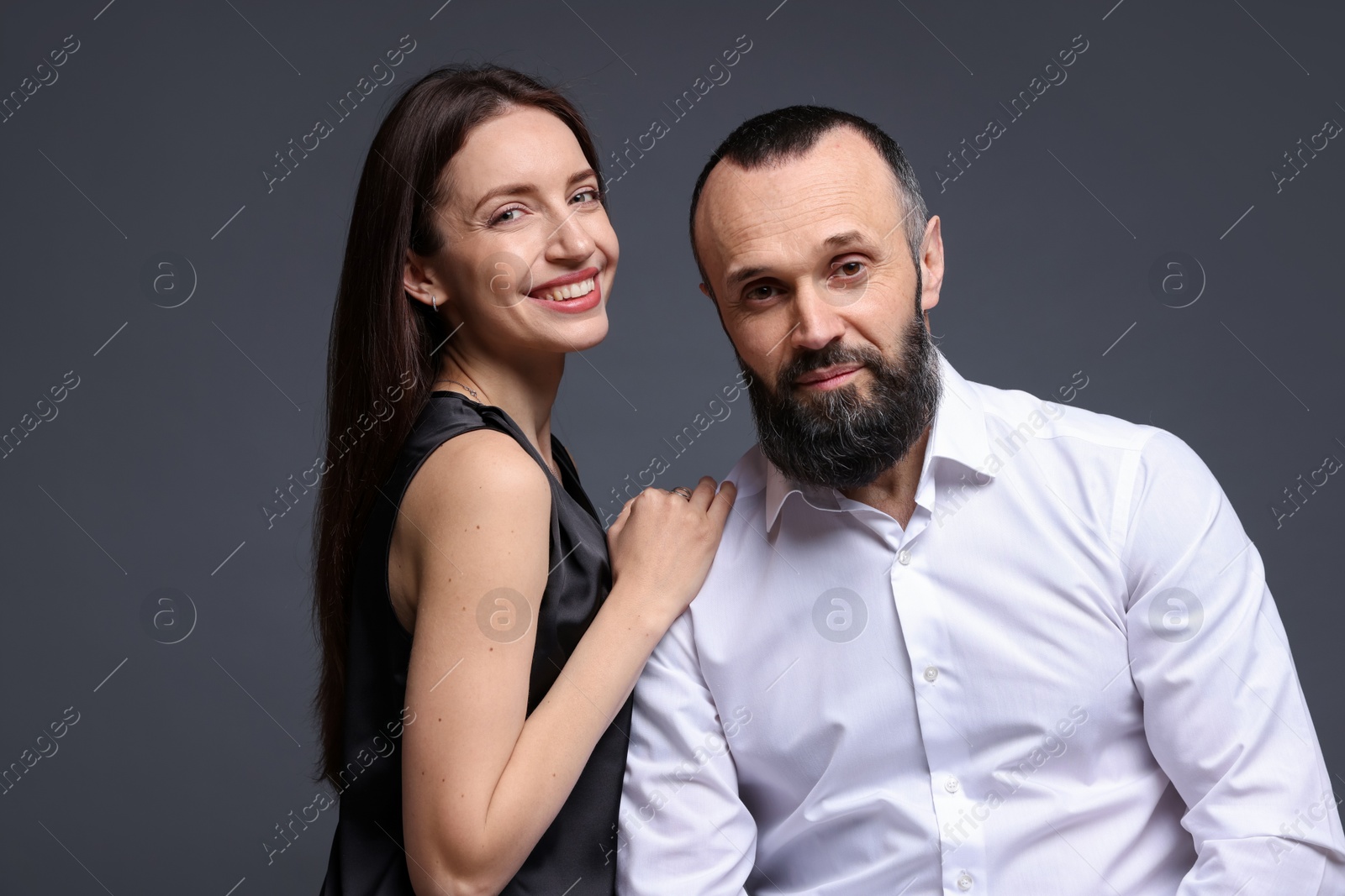 Photo of Portrait of happy daughter and father on dark grey background