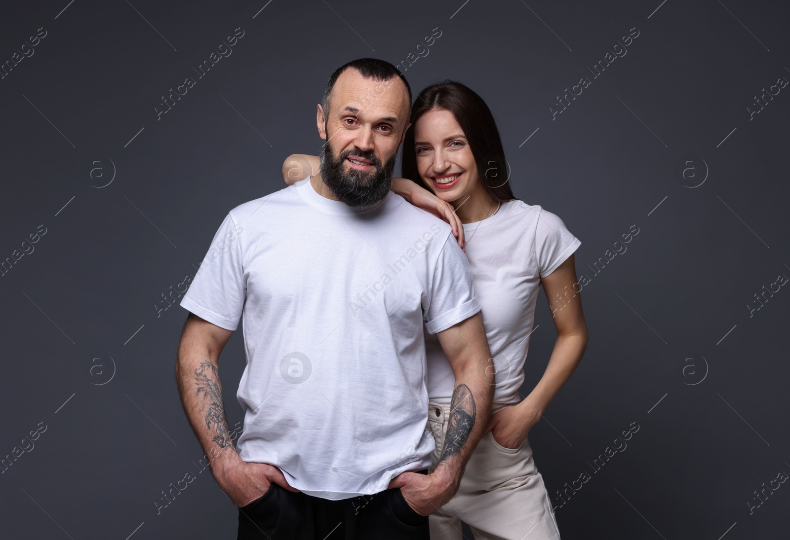 Photo of Portrait of happy daughter and father on dark grey background