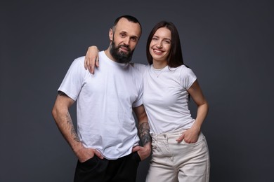 Photo of Portrait of happy daughter and father on dark grey background